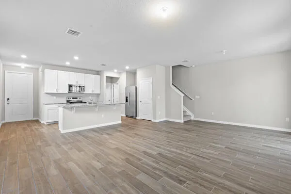 a view of kitchen with wooden floor and electronic appliances