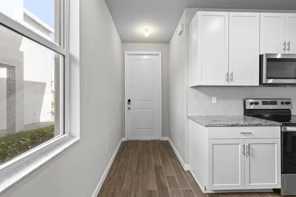 a kitchen with white cabinets and sink