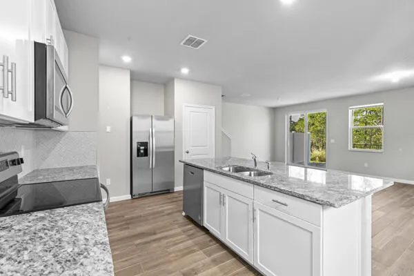 a kitchen with granite countertop a sink stove and refrigerator