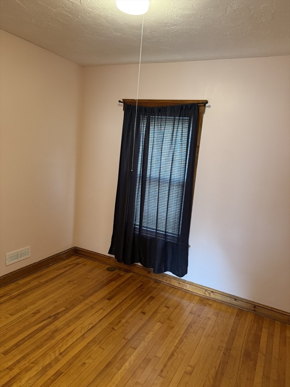 32 Clifton Street, Unit 2 Worcester, MA 01610 - Photo 5 of 12 a bedroom with a bed and a window