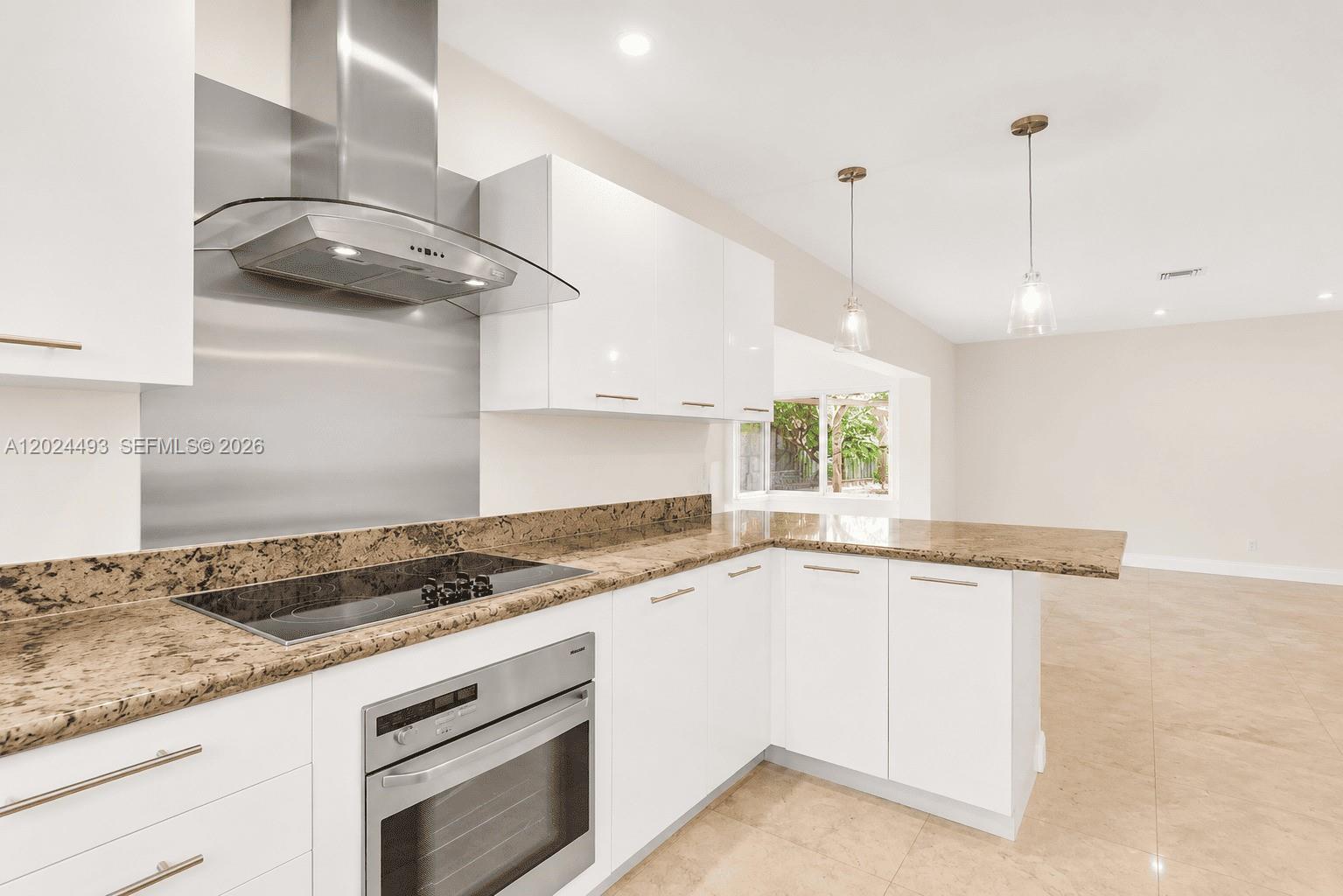 1995 Ixora Road North Miami, FL 33181 - Photo 19 of 23 a kitchen with granite countertop stainless steel appliances sink and cabinets