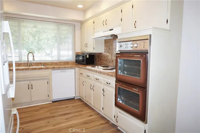 a kitchen with a sink stove and cabinets