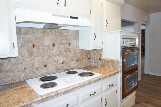 a kitchen with a sink cabinets stainless steel appliances and a large window