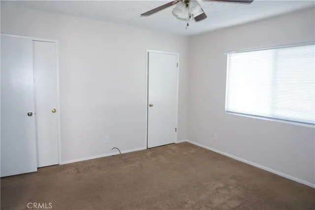 a room view with a ceiling fan and window
