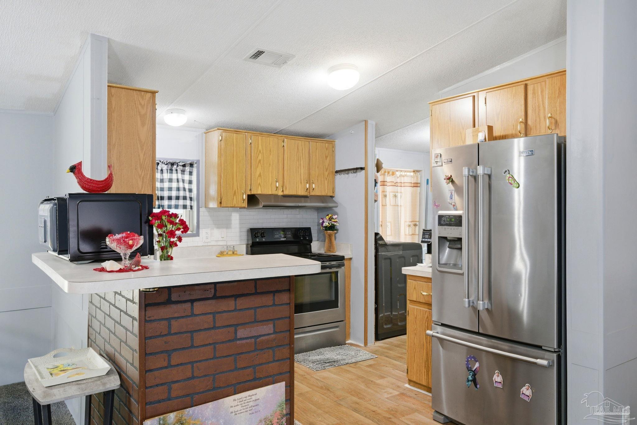 8962 Bluebell Street Milton, FL 32583 - Photo 12 of 35 a kitchen with a refrigerator and a stove