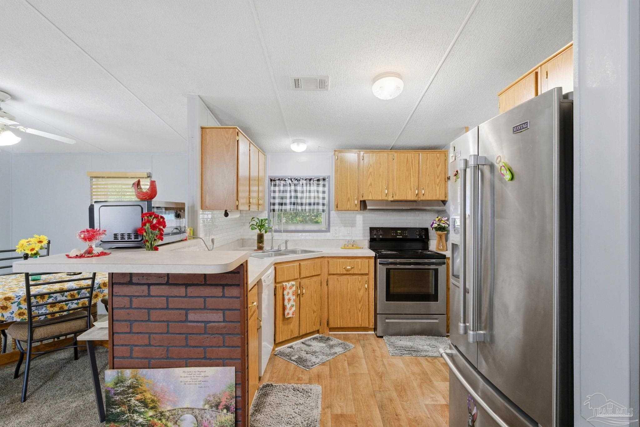 8962 Bluebell Street Milton, FL 32583 - Photo 13 of 35 a kitchen with a sink cabinets and stainless steel appliances