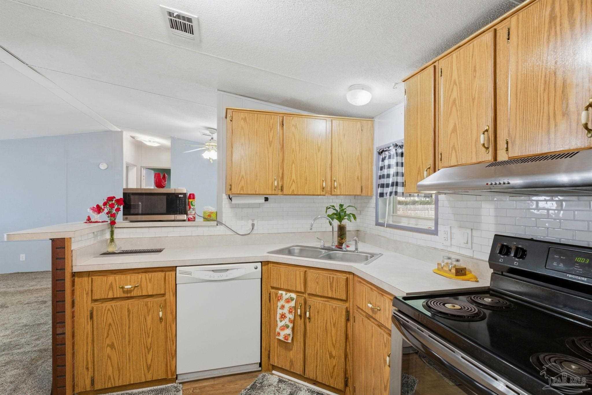 8962 Bluebell Street Milton, FL 32583 - Photo 14 of 35 a kitchen with a sink stove and cabinets