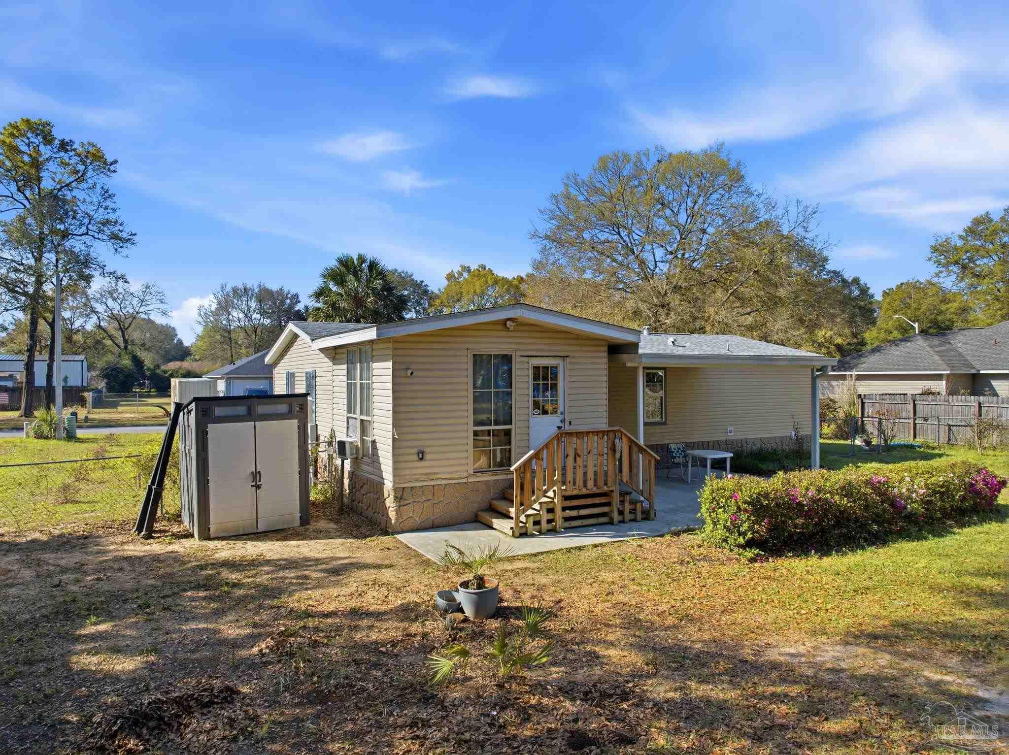 8962 Bluebell Street Milton, FL 32583 - Photo 32 of 35 a view of a house with backyard and a tree