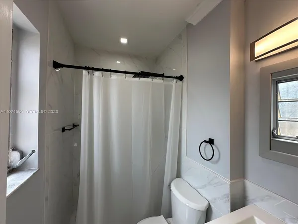 a view of a backyard with plants and large tree