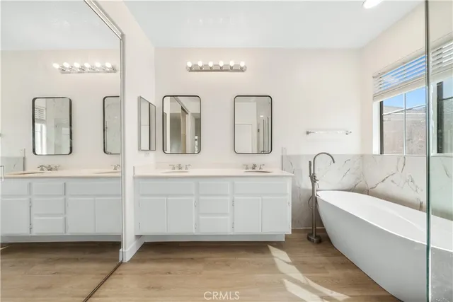a bathroom with double vanity and a mirror