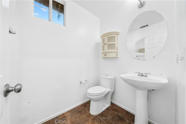 a bathroom with a sink toilet and a mirror
