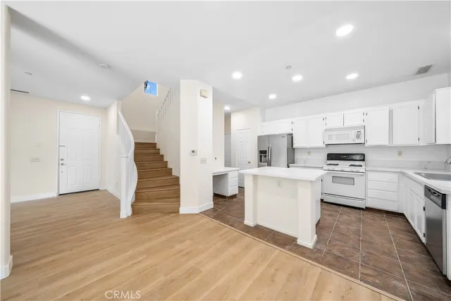 a kitchen with white cabinets and stainless steel appliances