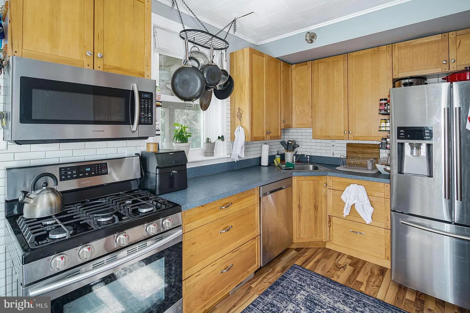 19 West Summit Avenue Haddonfield, NJ 08033 - Photo 3 of 12 a kitchen with stainless steel appliances granite countertop a stove a refrigerator a sink dishwasher and white cabinets with wooden floor