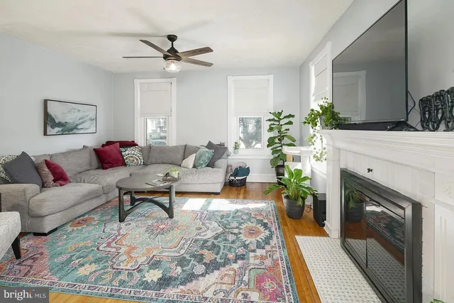 a living room with furniture a fireplace and a ceiling fan