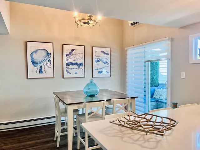 a living room with dining table and paintings