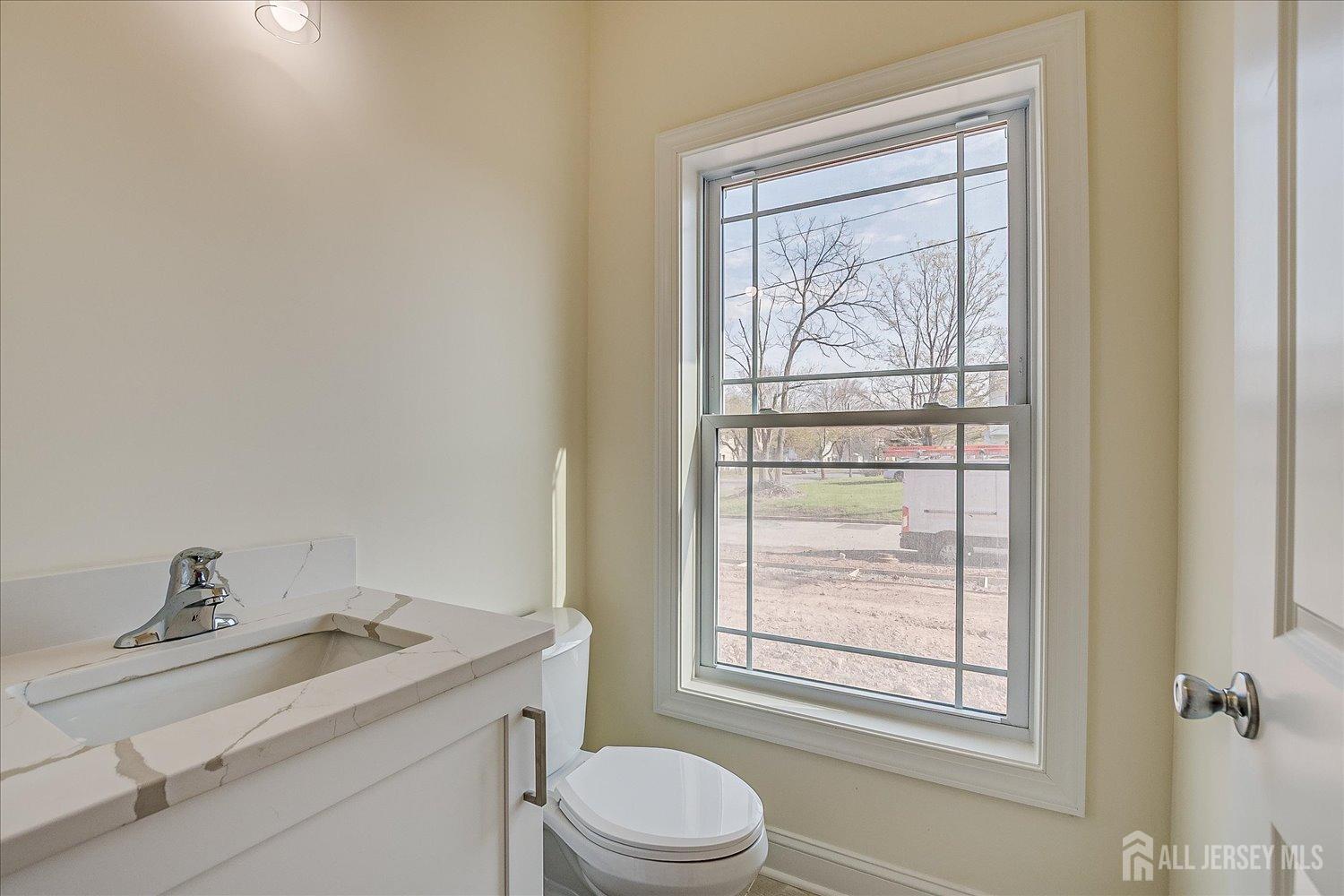 90 Hancock Road Piscataway, NJ 08854 - Photo 26 of 50 a bathroom with a granite countertop sink toilet a mirror and a window