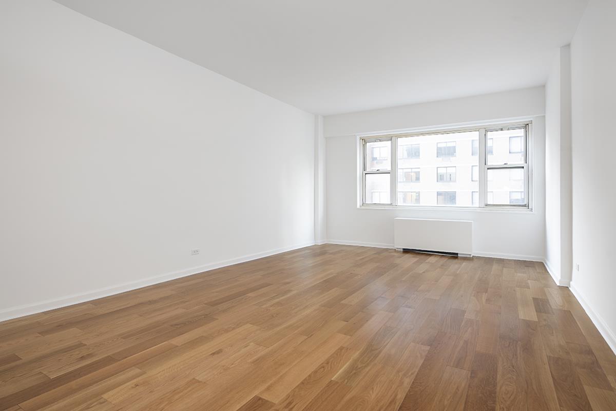 60 East 8th Street, Unit 10P Manhattan, NY 10003 - Photo 1 of 8 an empty room with wooden floor and windows