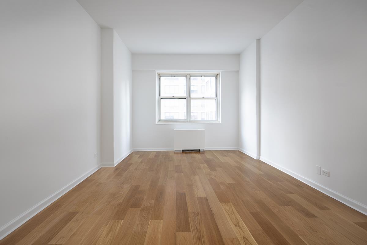 60 East 8th Street, Unit 10P Manhattan, NY 10003 - Photo 5 of 8 an empty room with wooden floor and windows