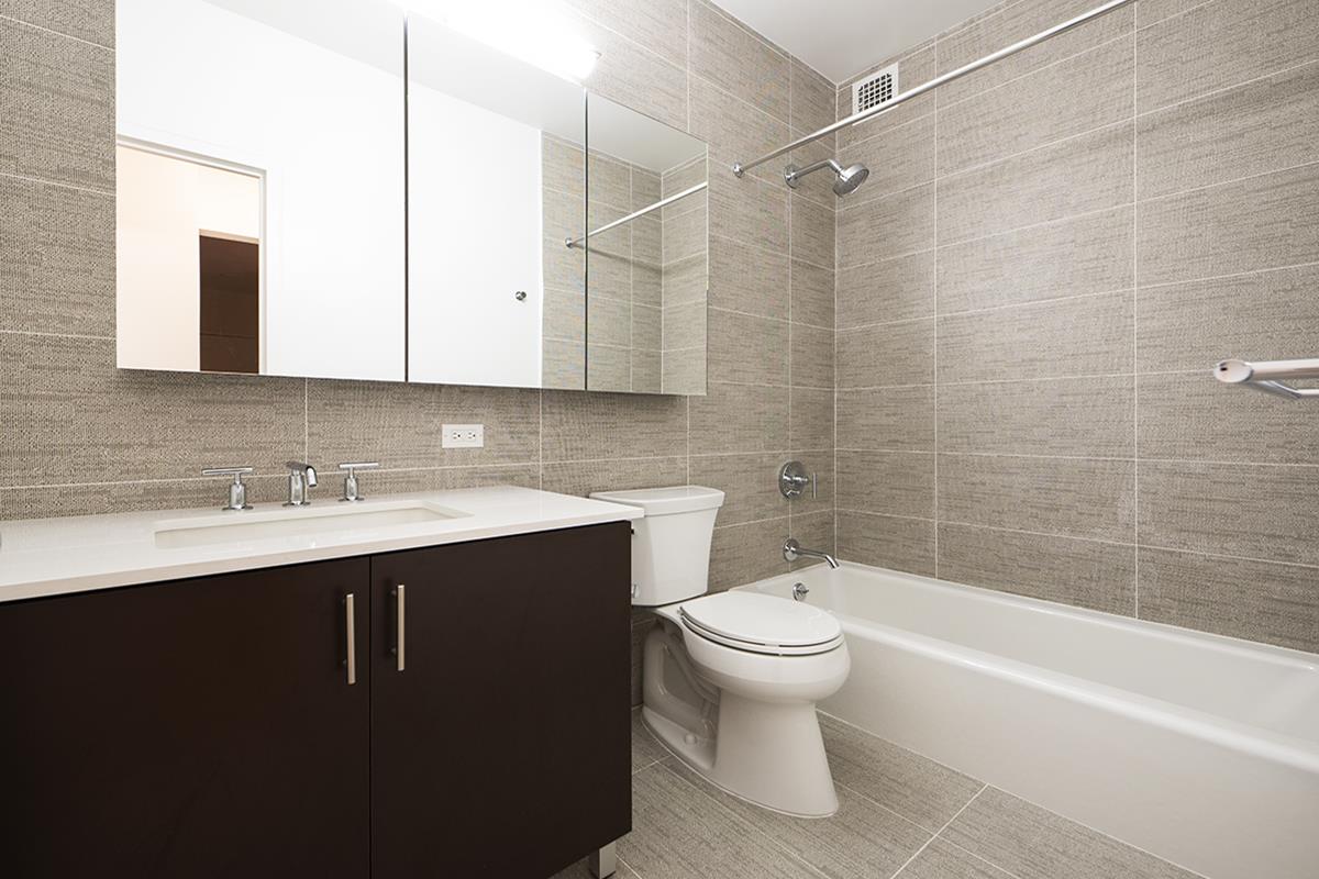 60 East 8th Street, Unit 10P Manhattan, NY 10003 - Photo 7 of 8 a bathroom with a sink toilet double vanity and bathtub