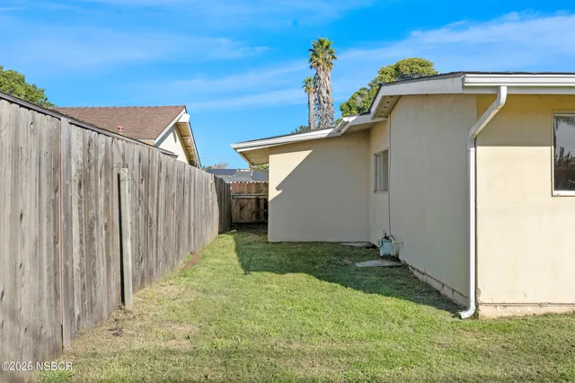 an aerial view of a house with a yard and a large tree