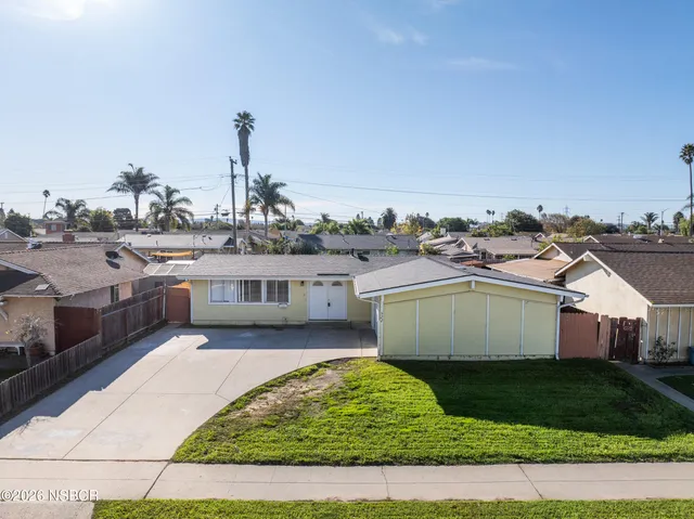 an aerial view of a residential houses with yard