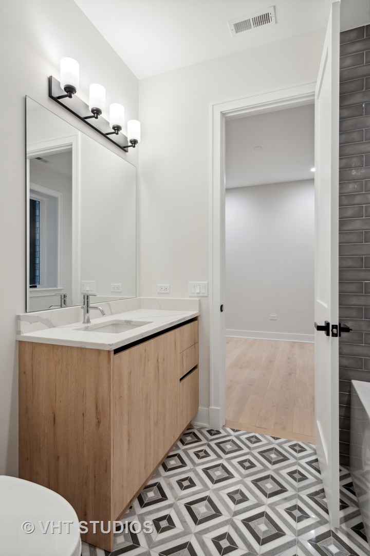 232 South Green Street, Unit 3N Chicago, IL 60607 - Photo 23 of 30 a bathroom with a sink a mirror and a shower