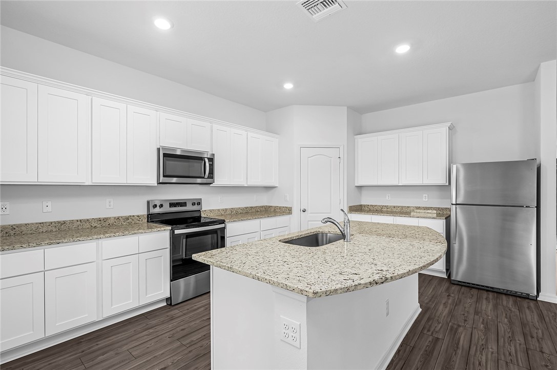 7926 105th Avenue Vero Beach, FL 32967 - Photo 7 of 18 a kitchen with granite countertop a sink stove and refrigerator