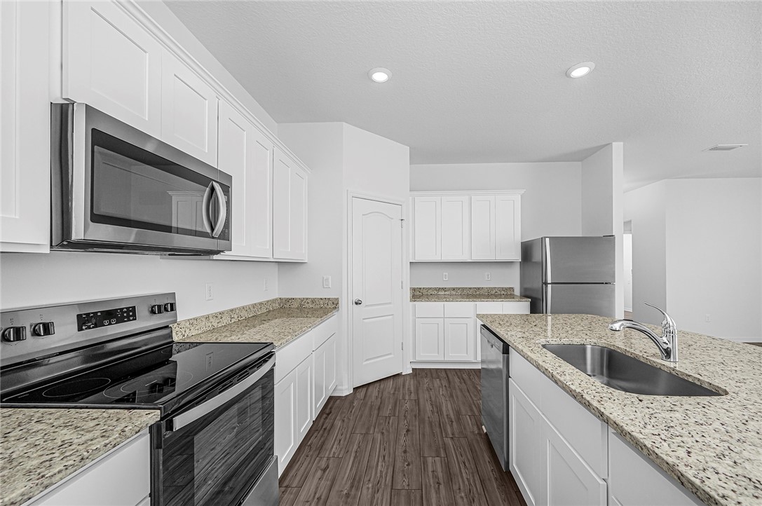 7926 105th Avenue Vero Beach, FL 32967 - Photo 8 of 18 a kitchen with granite countertop a sink stainless steel appliances and cabinets