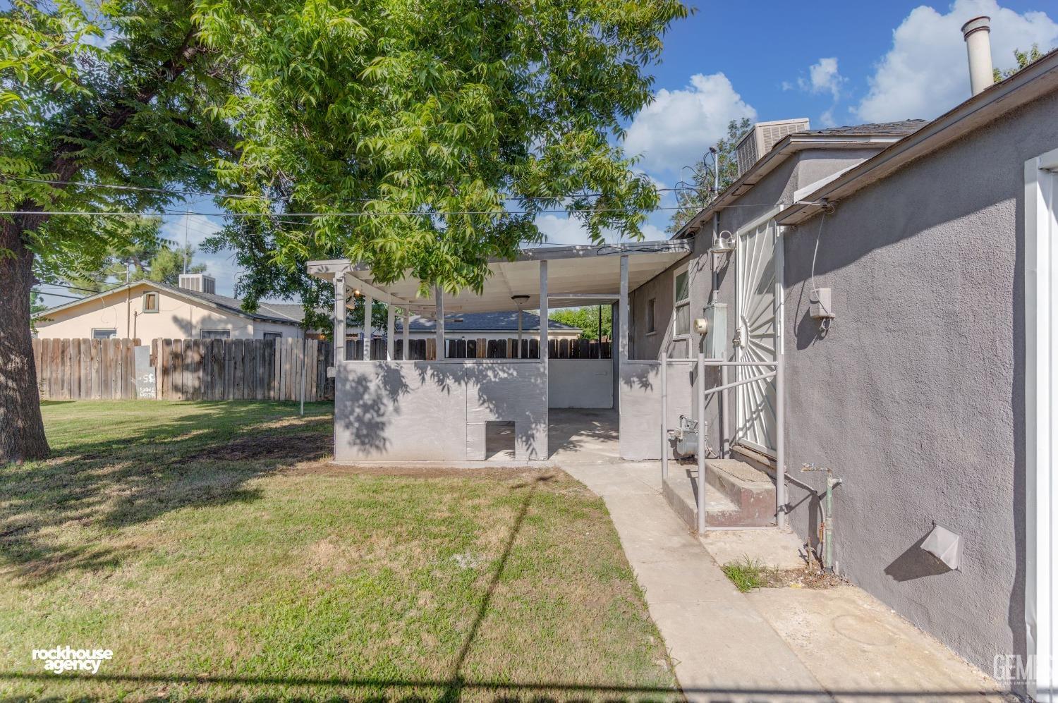 Undisclosed Address Bakersfield, CA 93308 - Photo 13 of 17 a view of a patio with table and chairs with wooden fence and large trees