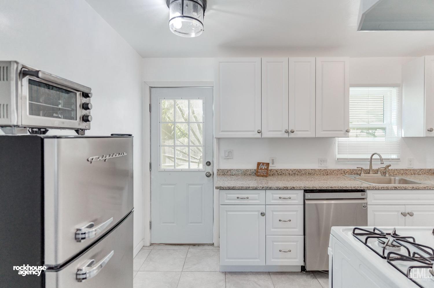 Undisclosed Address Bakersfield, CA 93308 - Photo 7 of 17 a kitchen with granite countertop a sink stove and refrigerator