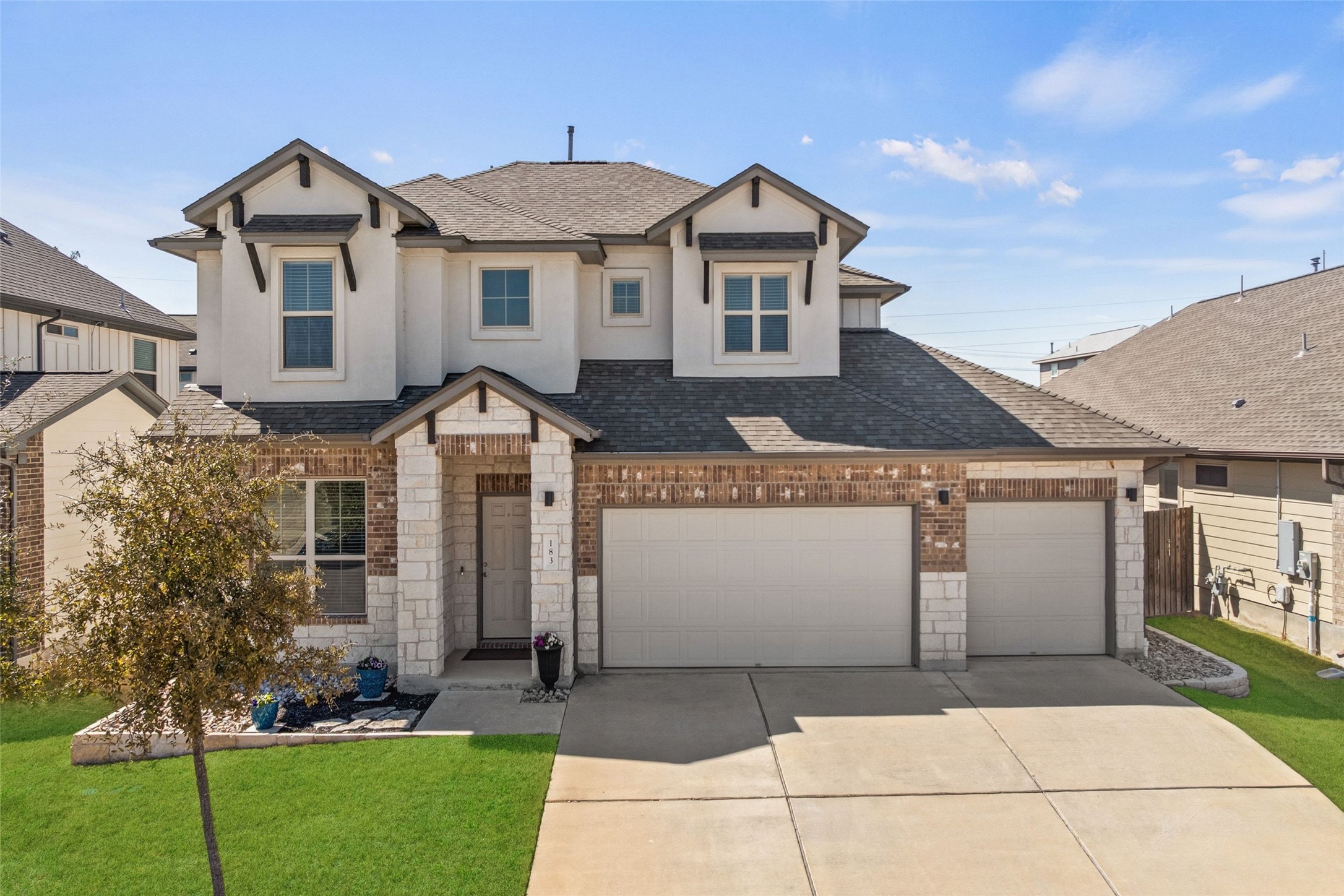 a front view of a house with a yard and trees