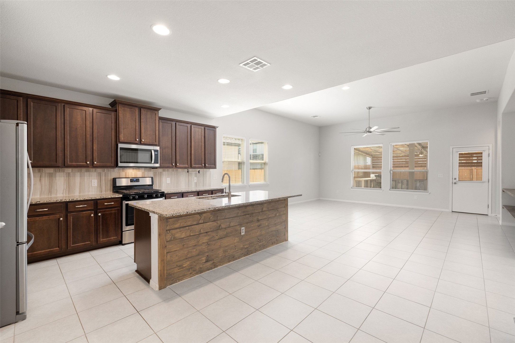 183 Concho Creek Loop Leander, TX 78641 - Photo 10 of 35 a large kitchen with stainless steel appliances granite countertop a stove top oven a sink dishwasher and a refrigerator