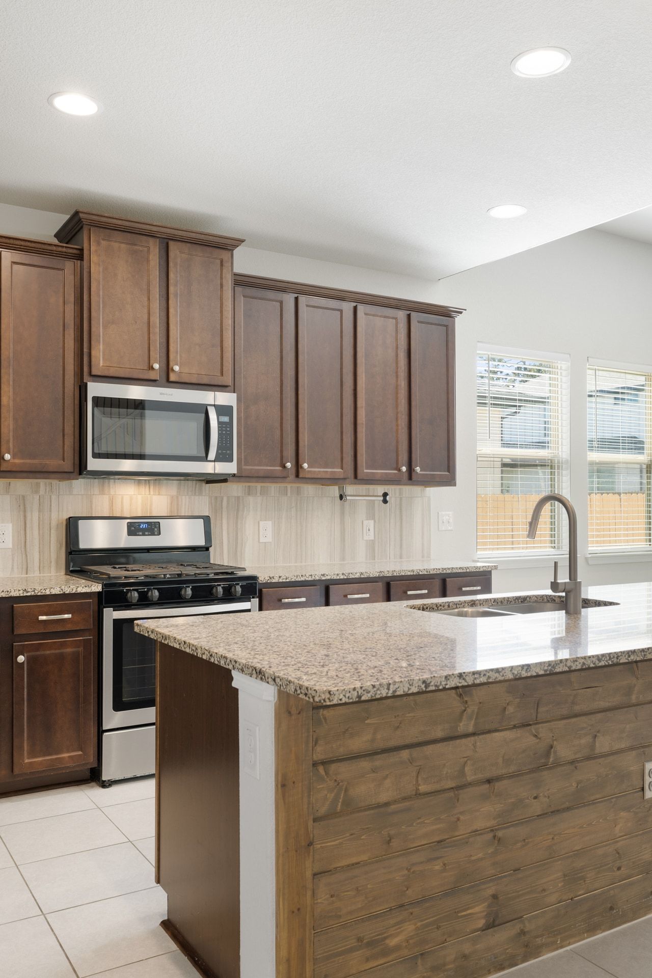 183 Concho Creek Loop Leander, TX 78641 - Photo 11 of 35 a kitchen with stainless steel appliances granite countertop a stove a sink and a microwave