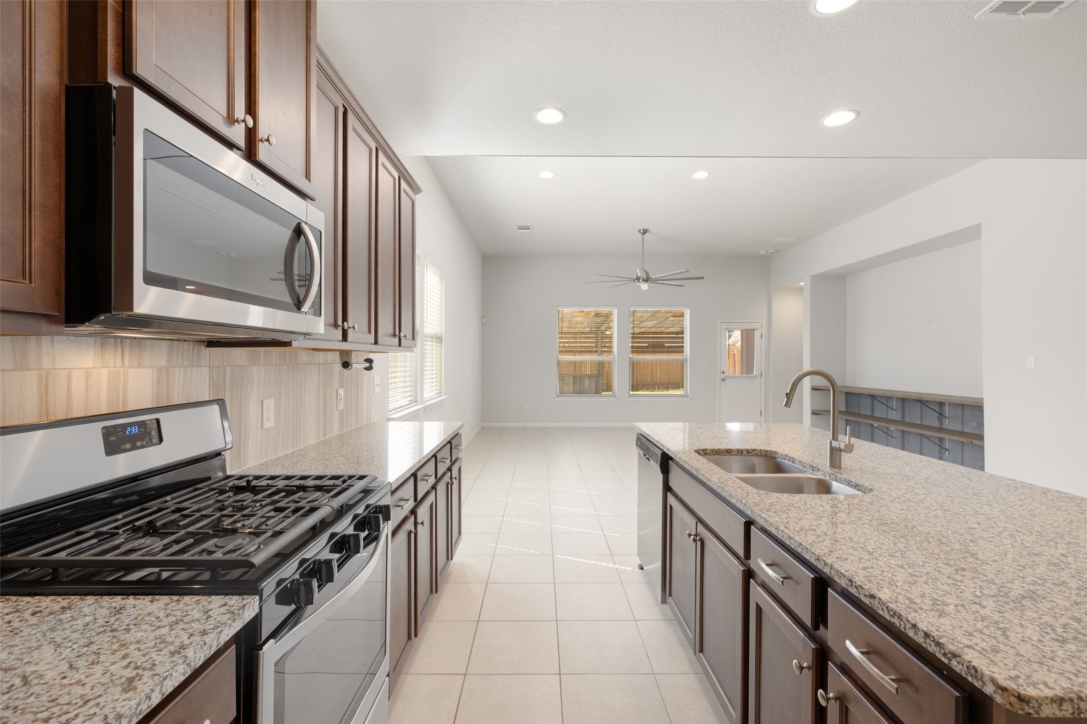 183 Concho Creek Loop Leander, TX 78641 - Photo 12 of 35 a kitchen with granite countertop stainless steel appliances a sink stove and cabinets