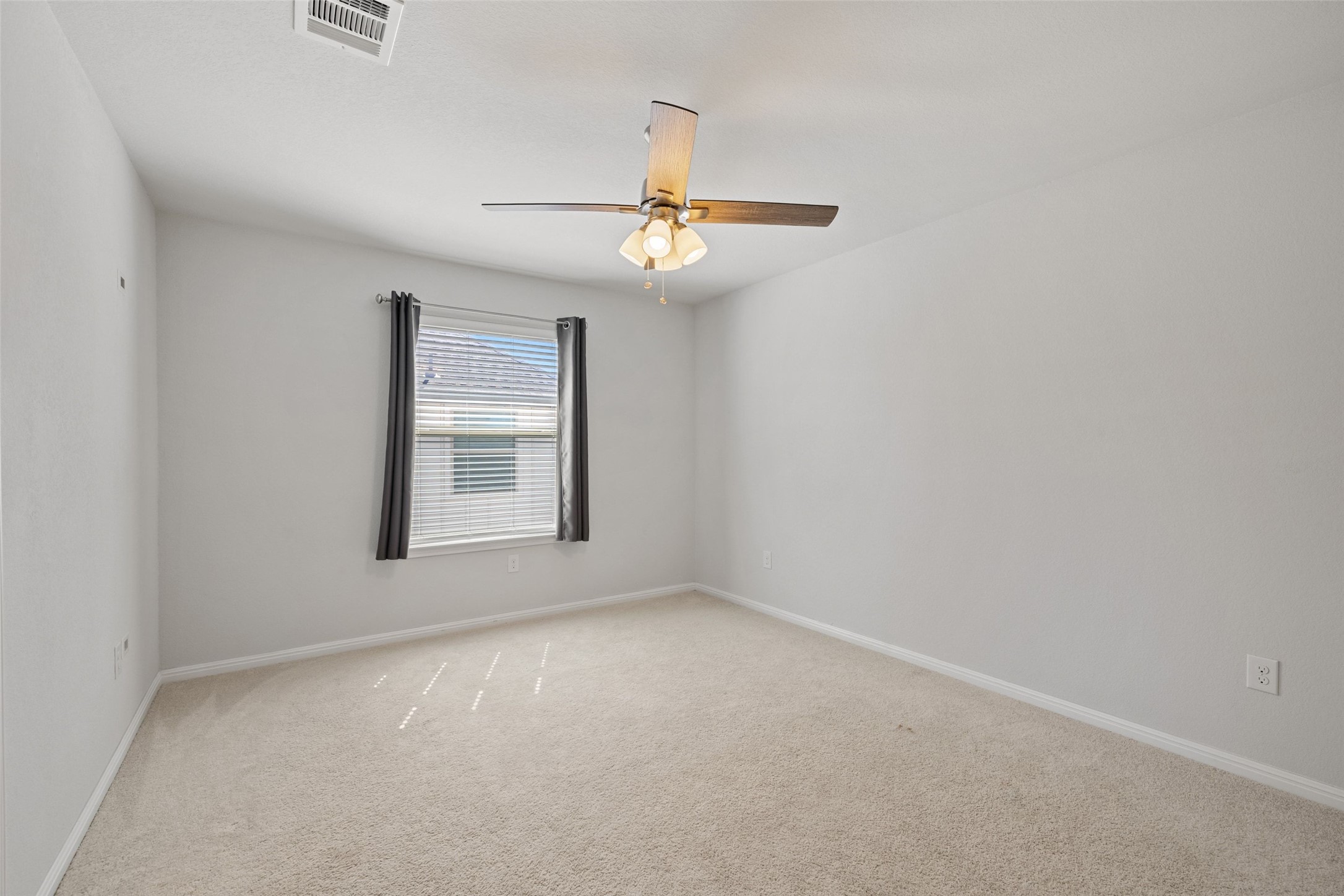 183 Concho Creek Loop Leander, TX 78641 - Photo 27 of 35 an empty room with a window and ceiling fan