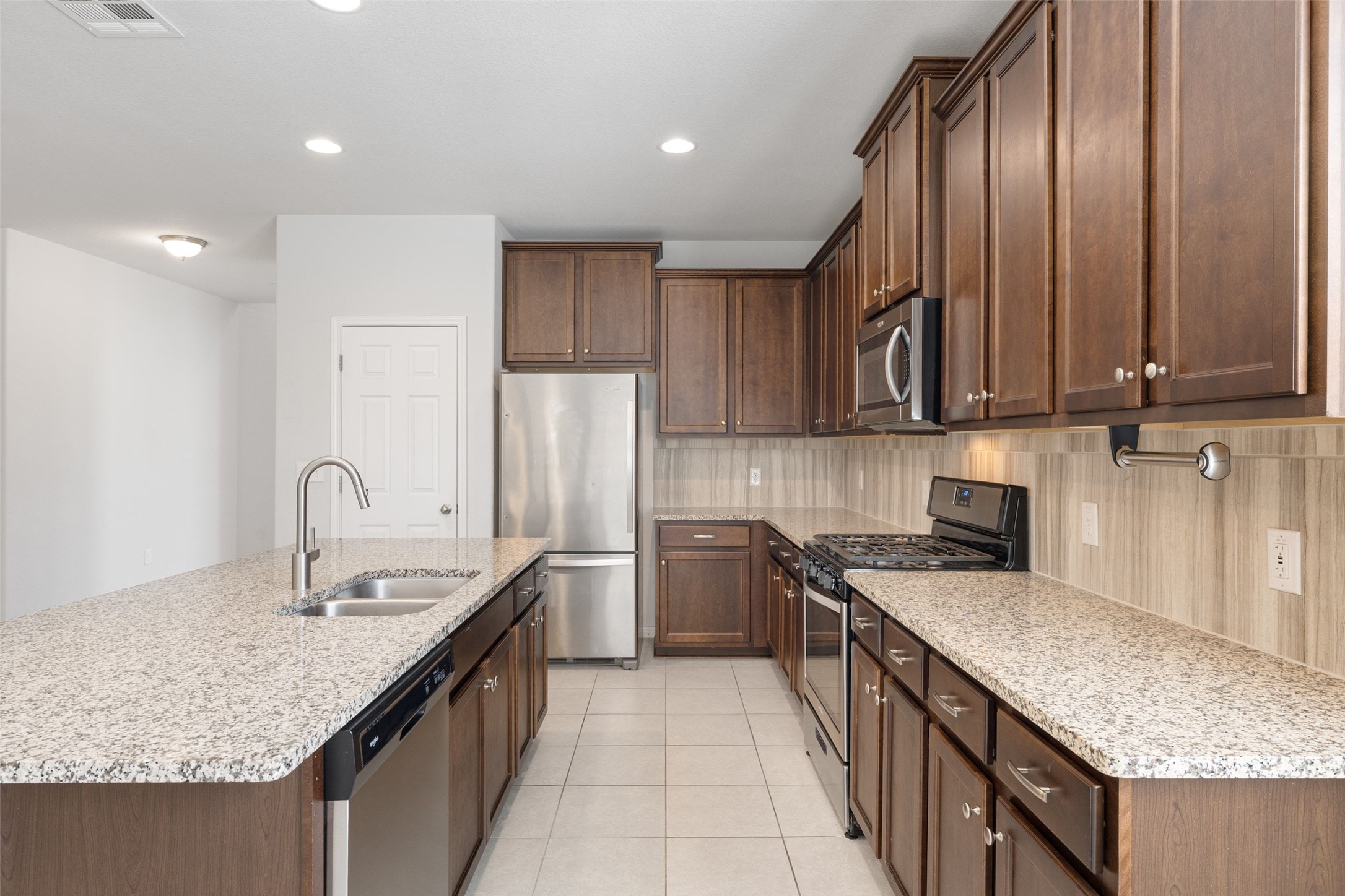 183 Concho Creek Loop Leander, TX 78641 - Photo 7 of 35 a kitchen with stainless steel appliances granite countertop a sink stove and refrigerator