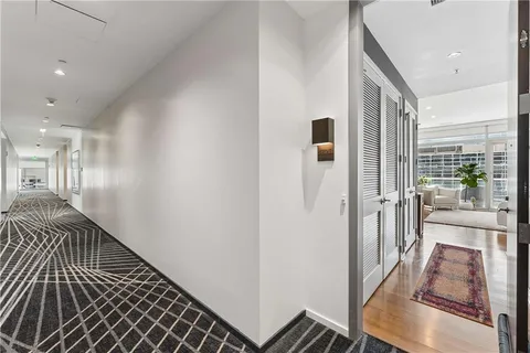 a view of a hallway with wooden floor and staircase