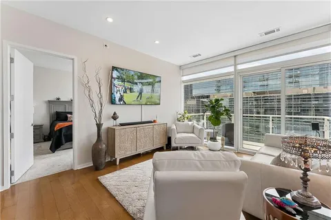 a living room with stainless steel appliances kitchen island granite countertop a table chairs and a view of living room