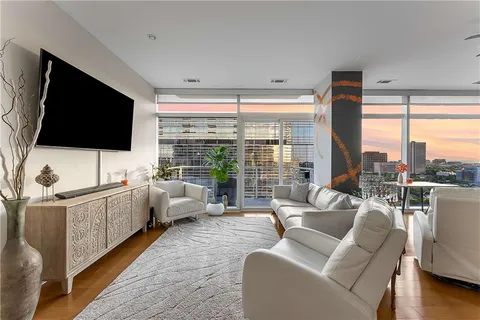 a kitchen with stainless steel appliances granite countertop a stove a sink dishwasher a dining table and chairs with wooden floor