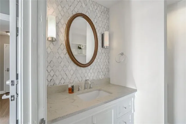 a bathroom with a granite countertop sink a mirror and a shower
