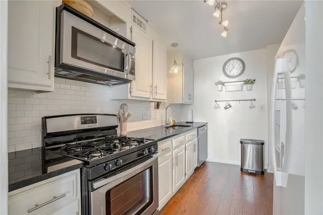 a kitchen with stainless steel appliances a stove a microwave and cabinets