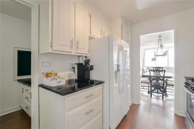 a kitchen with stainless steel appliances white cabinets and wooden floor