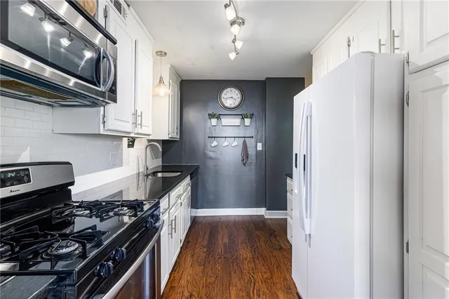 a kitchen with stainless steel appliances granite countertop a refrigerator and a stove top oven