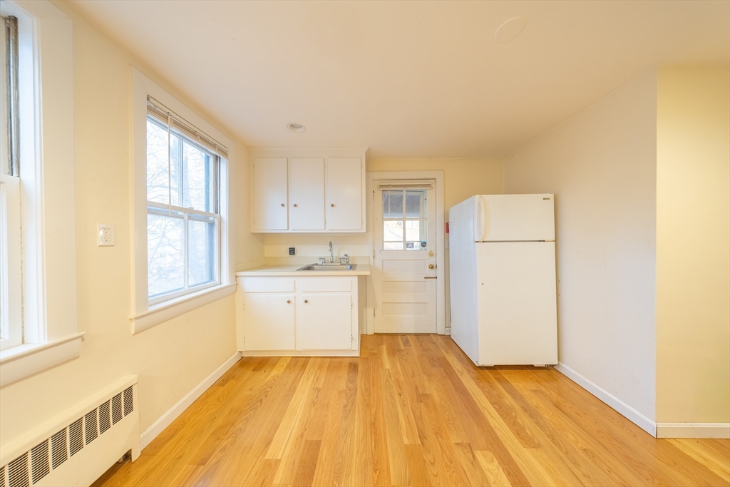 1026 Chestnut Street, Unit 2A Newton, MA 02464 - Photo 3 of 17 a view of a kitchen with wooden floor and electronic appliances