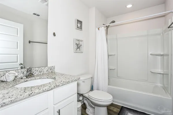 a bathroom with a granite countertop sink toilet and shower
