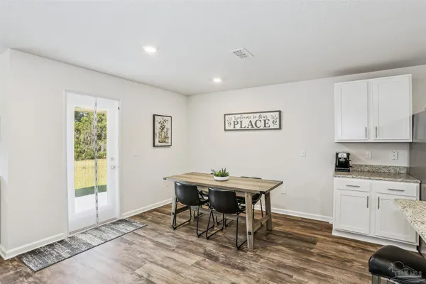 a view of a kitchen with a table and chairs in it