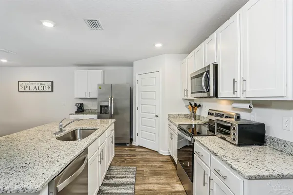 a kitchen with a stove a sink a microwave and refrigerator