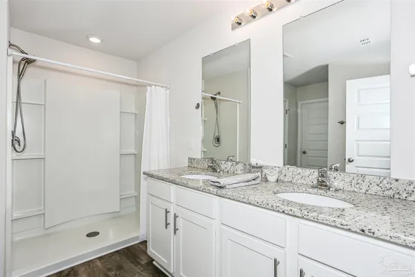 a bathroom with a granite countertop sink mirror and shower