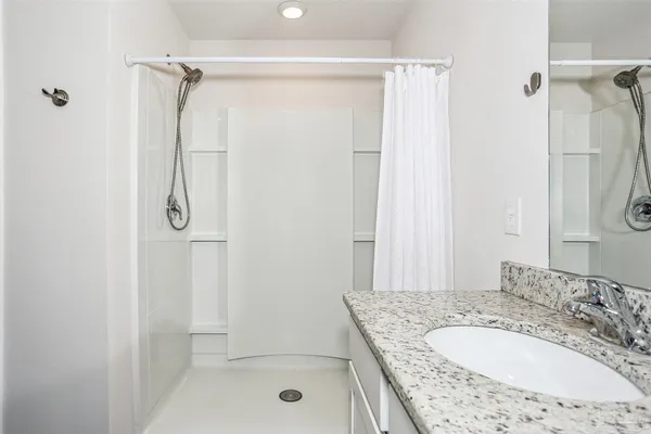 a bathroom with a granite countertop shower sink and vanity