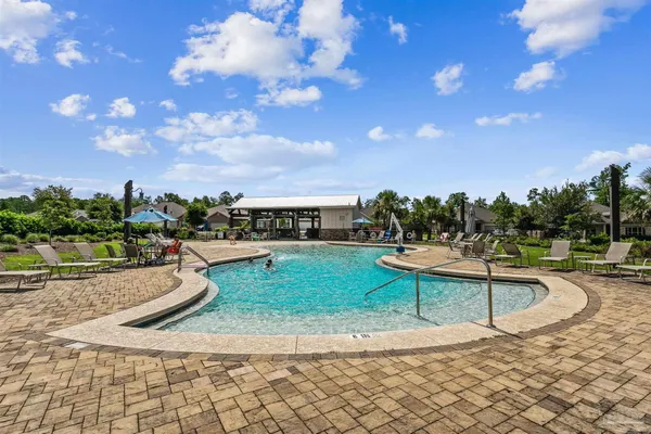 a view of a swimming pool with lawn chairs and a fire pit